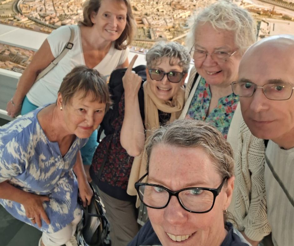 A group of people posing for a photo in a museum